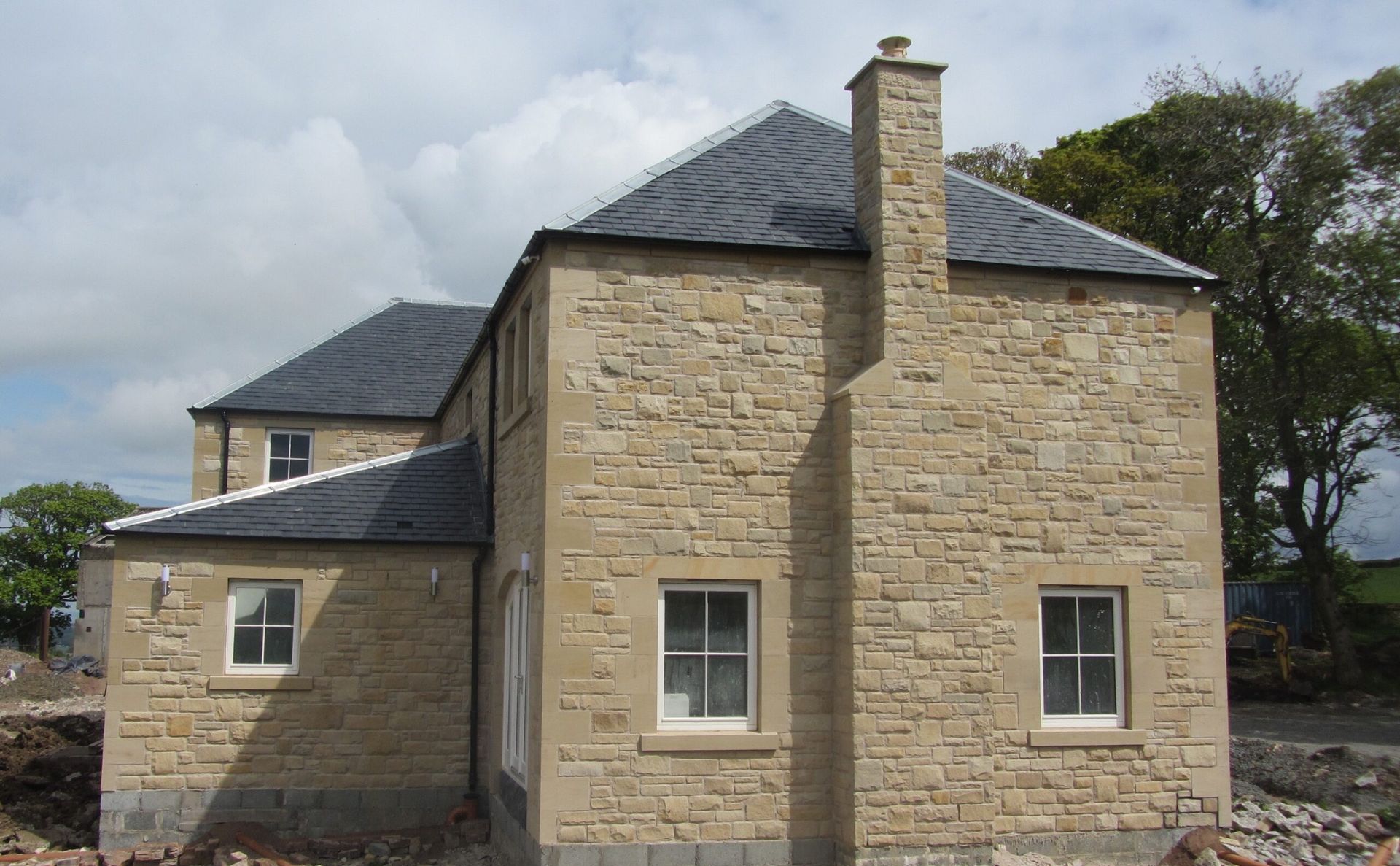 Handcrafted sandstone house exterior by Edinburgh stone masons, showcasing traditional stonework.