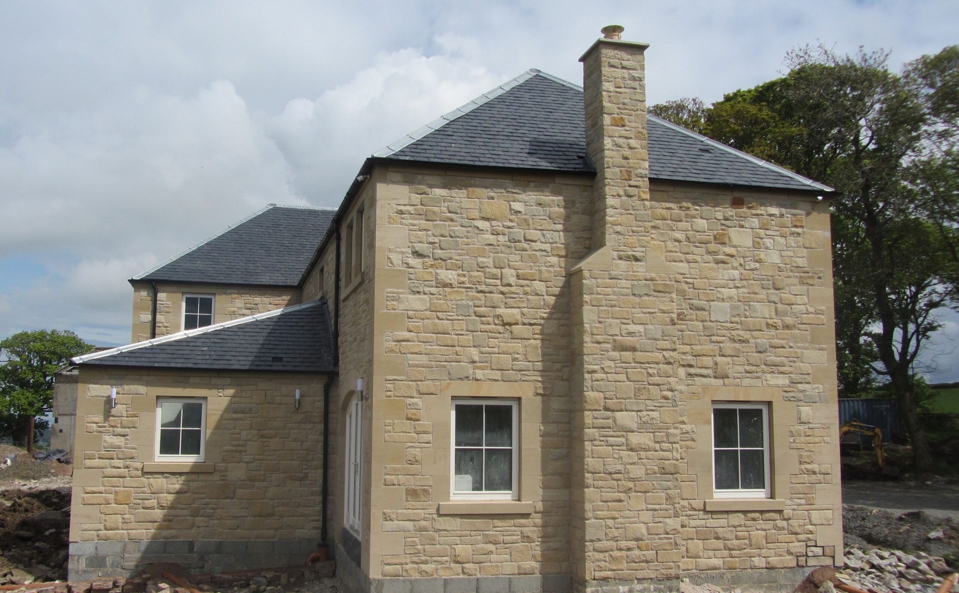 Handcrafted sandstone house exterior by Edinburgh stone masons, showcasing traditional stonework.