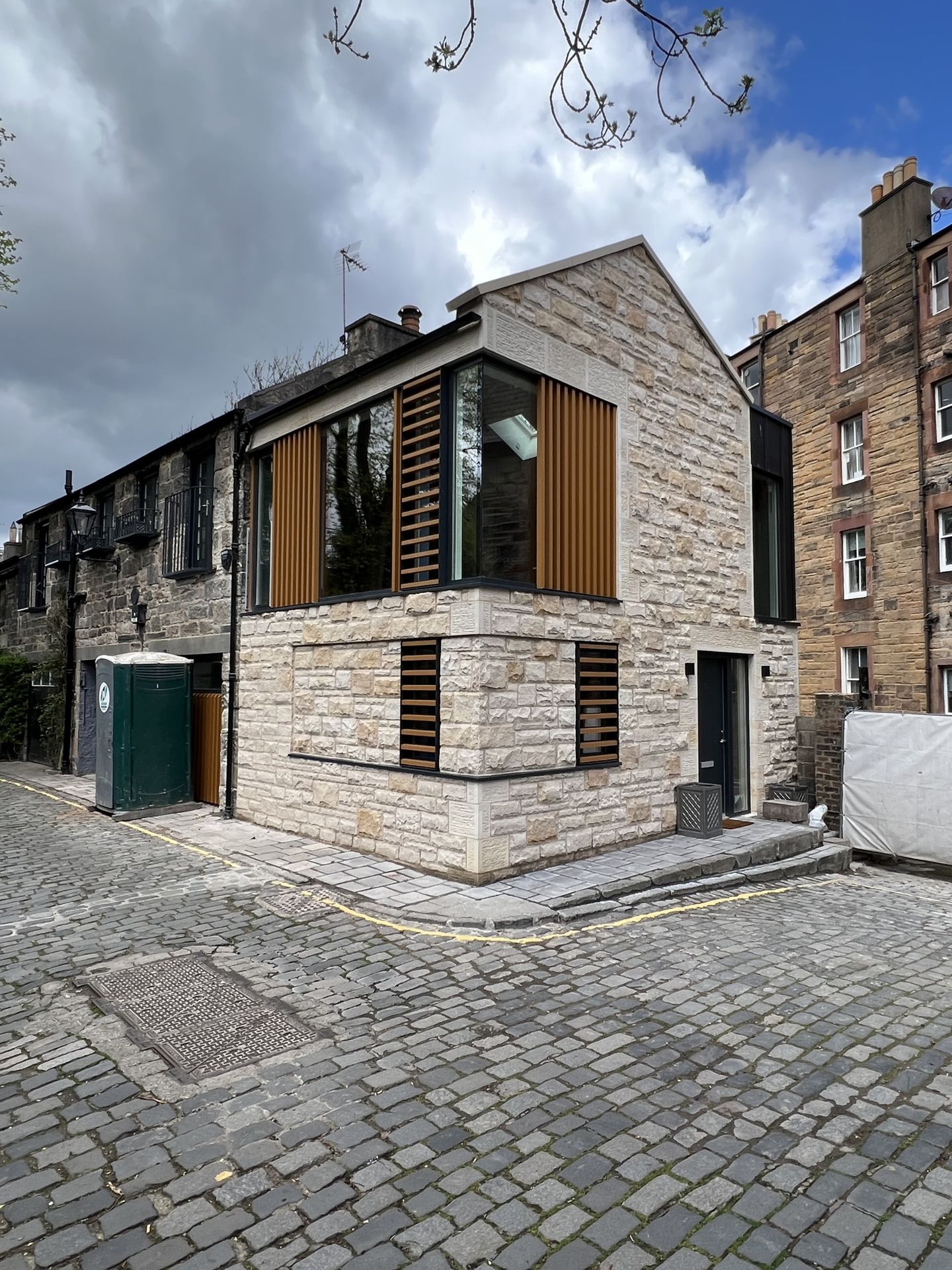 Traditional stone masonry with modern architectural design and wooden accents in Edinburgh.