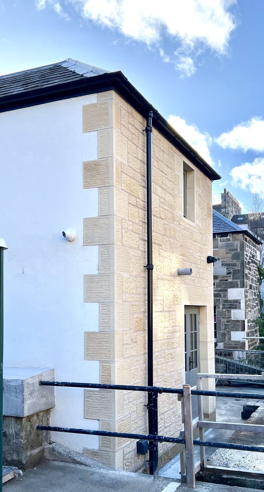 Elegant sandstone masonry on modern building facade, expert Edinburgh stonemasons craftsmanship.