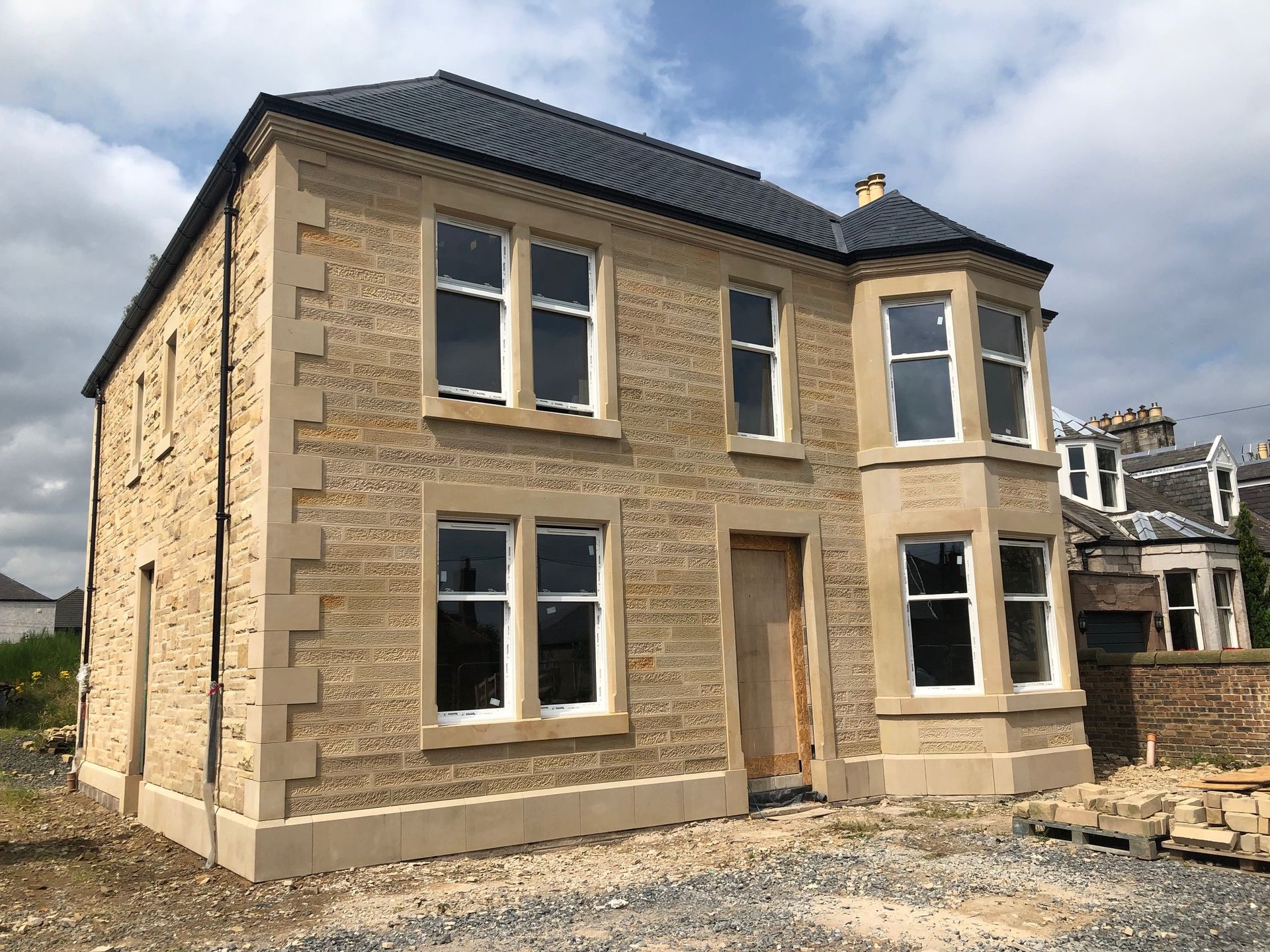 Traditional Scottish stone masonry building under construction, showcasing expert craftsmanship by IMC Stonemasons Limited.
